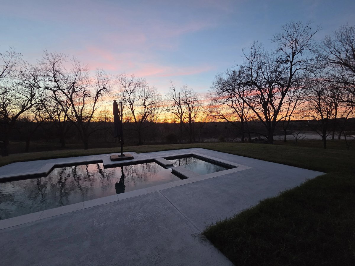 Modern decorative concrete pool deck at dusk in the Brazos Valley
